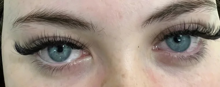 A pair of blue eyes with dark lash extensions