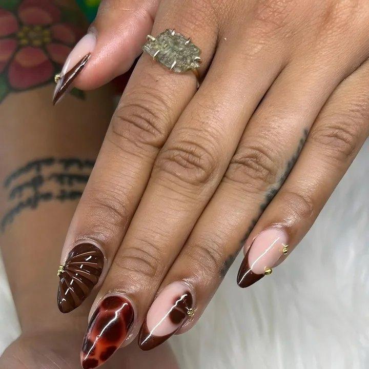 Almond nails with tortoiseshell, cocoa French tips and small gold studs